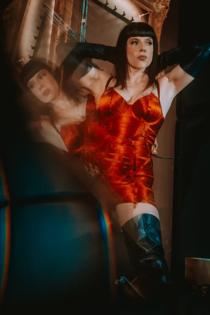 Berlin Domina Lady Vyra wearing a red lingerie dress and leather boots